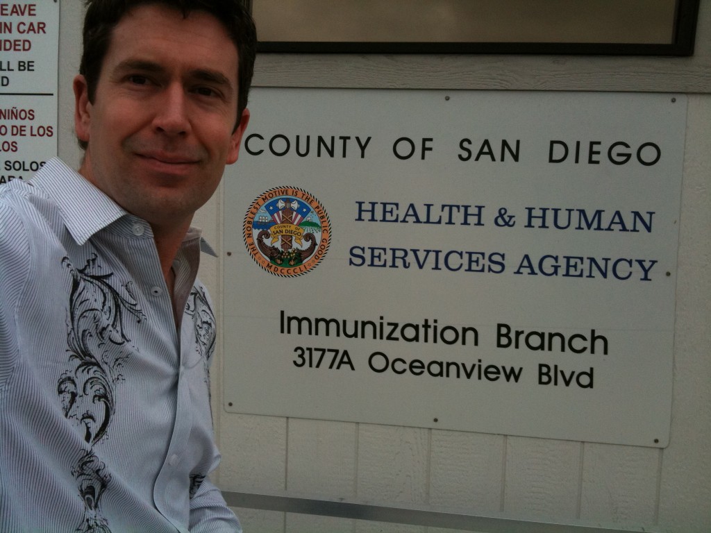 John in Front of San Diego Immunization Clinic Sign